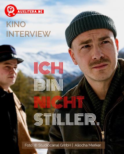Der Schauspieler Albrecht Schuch in seiner Rolle als Stiller, er steht am rechten Rand des Bildes, zu sehen bis zum Oberkörper. Er trägt eine Dockermütze und einen leichten Bart. Im Hintrergrund eine Gebirgskette, ganz links sieht man angeschnitten eine weitere Person.