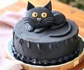 A chocolate Halloween cake treat with a cute sugary black cat sitting on the top of it!