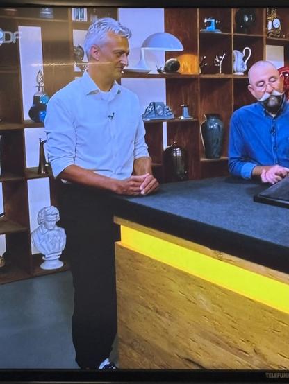 Ein abfotografierter Fernseher, das eine aktuelle Szene aus der Serie zeigt. Der Teilnehmer neben Horst sieht wegen schlechter Beleuchtung schon fast so aus, als hätte er grüne Haut.