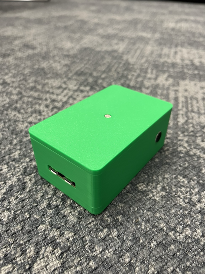 The back of A mobile battery powered sensor device for wireless communication of movement for sonification. It’s green!