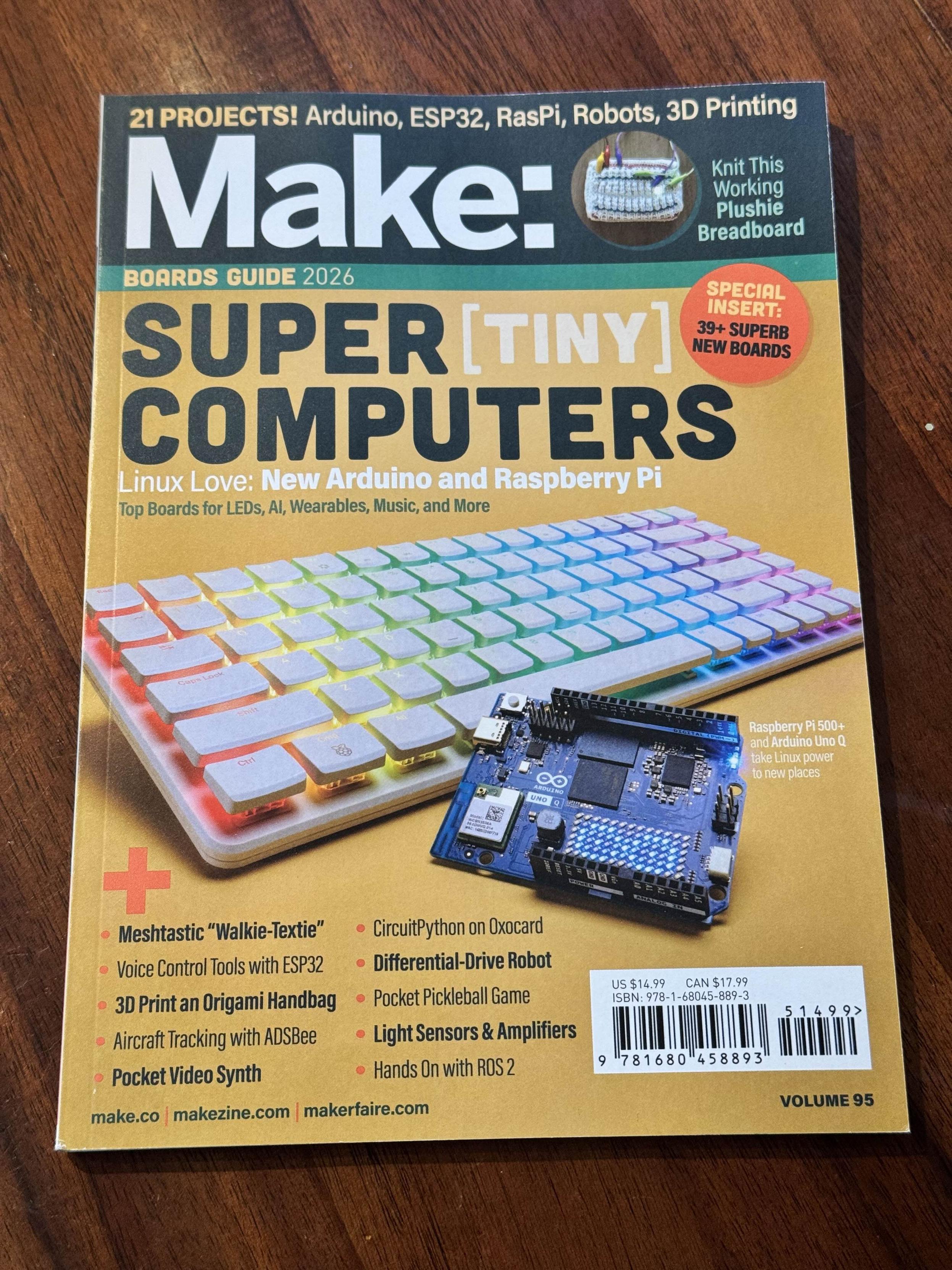 Cover image of Make: Magazine Volume 95 featuring the “Boards Guide 2026.” The top half includes a bold red MAKE: logo with white background. Below, the main visual shows a custom hardware board in close-up with multicolored electronic components, USB ports, and traces. Text overlay reads: “Boards Guide 2026: The Word is Board.” The design is clean and tech-focused, representing DIY hardware innovation.