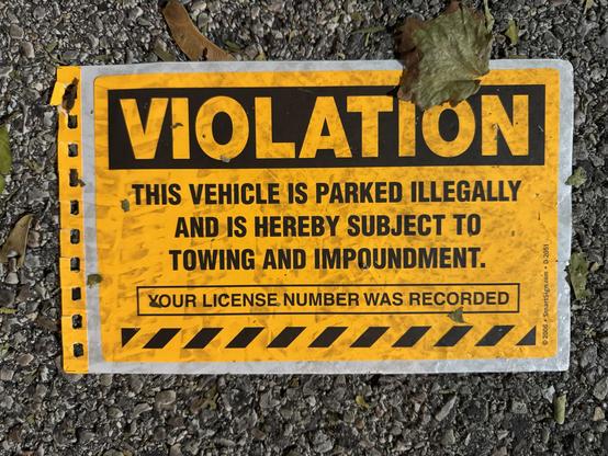 Found lying in a parking lot at night, an orange and black sticker still on its adhesive backing. Text reads:

Violation

This vehicle is parked illegally and is hereby subject to to towing and impoundment.

Your license number was recorded

© 2006 · SmartSign.com · D-2051