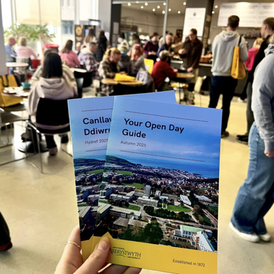 Photo of visitors to an Open Day, starting at the meeting point in the Arts Centre. In the foreground, you can see the Your Open Day Guide provided to all visitors.
