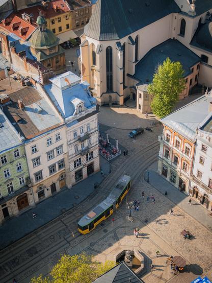 Blick von oben auf eine Straßenszene mit Straßenbahn