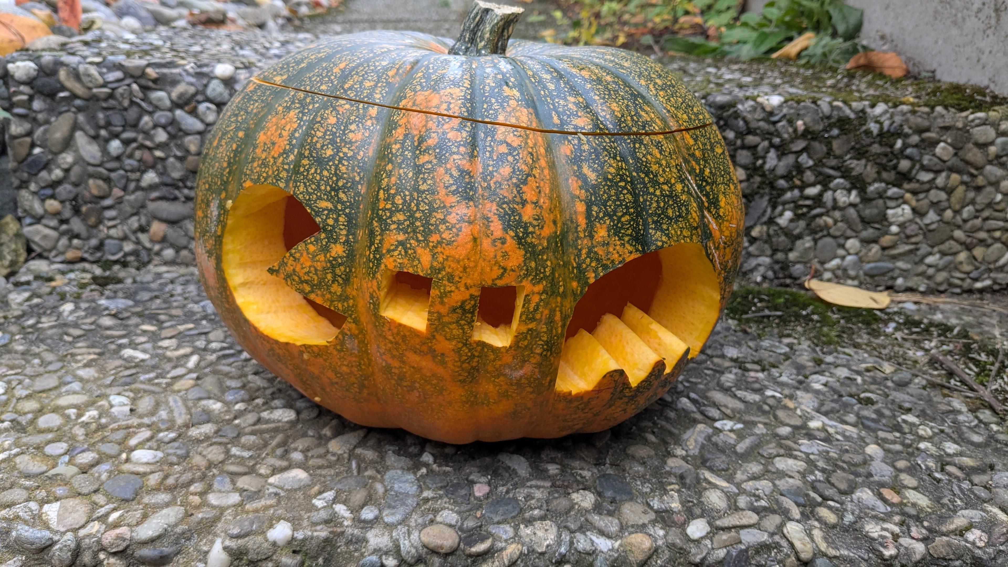 Pumpkin with a Pacman carved out, two dots in the middle, and a pacman monster. The pumpkin is on the floor.