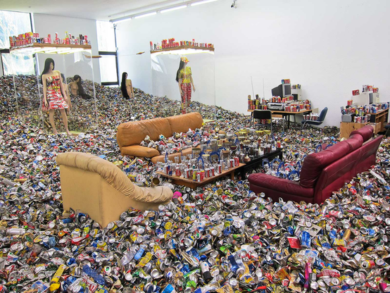 An entire museum filled with tens of discarded furniture, thousands of aluminum cans and other discarded items, forcing visitors to navigate through an overwhelming environment of consumer waste.