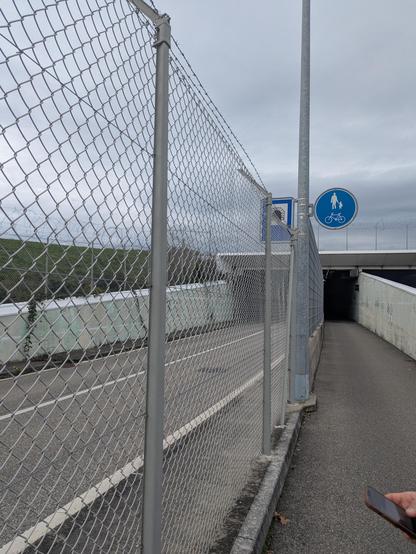 Tunnel routier et piéton sous la piste l'aéroport de Genève. À gauche du grillage la route est inaccessible depuis la Suisse. Elle permet de rejoindre le secteur français de l'aéroport sans passer par la douane.