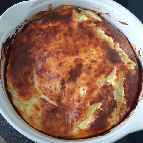 Cheesecake in an oven dish, brown on top. 