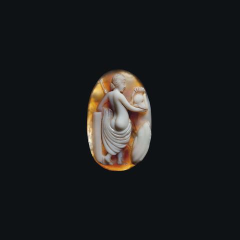 A Roman agate cameo depicting Venus Victrix, dated circa 1st century CE. Venus is shown from behind, a helmet in hand, and a himation draped just below her ample bum. Beside her a round shield rests on the ground and a column serves as an arm rest.