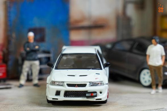 A Mitsubishi Lancer RS Evolution 6, Monte Carlo Edition, Scortia White by Hobby Japan in 1:64 scale with 1:64 figures on AREA 164.