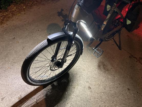 An LED strip strapped to the bottom tube of an ebike.