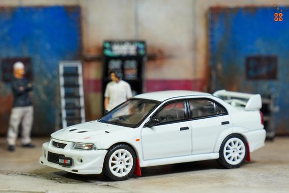 A left side of Mitsubishi Lancer RS Evolution 6, Monte Carlo Edition, Scortia White by Hobby Japan in 1:64 scale with 1:64 figures on AREA 164.