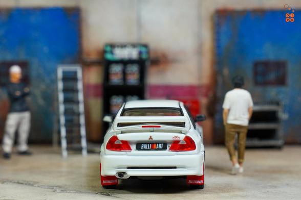 A rear side of Mitsubishi Lancer RS Evolution 6, Monte Carlo Edition, Scortia White by Hobby Japan in 1:64 scale with 1:64 figures on AREA 164.