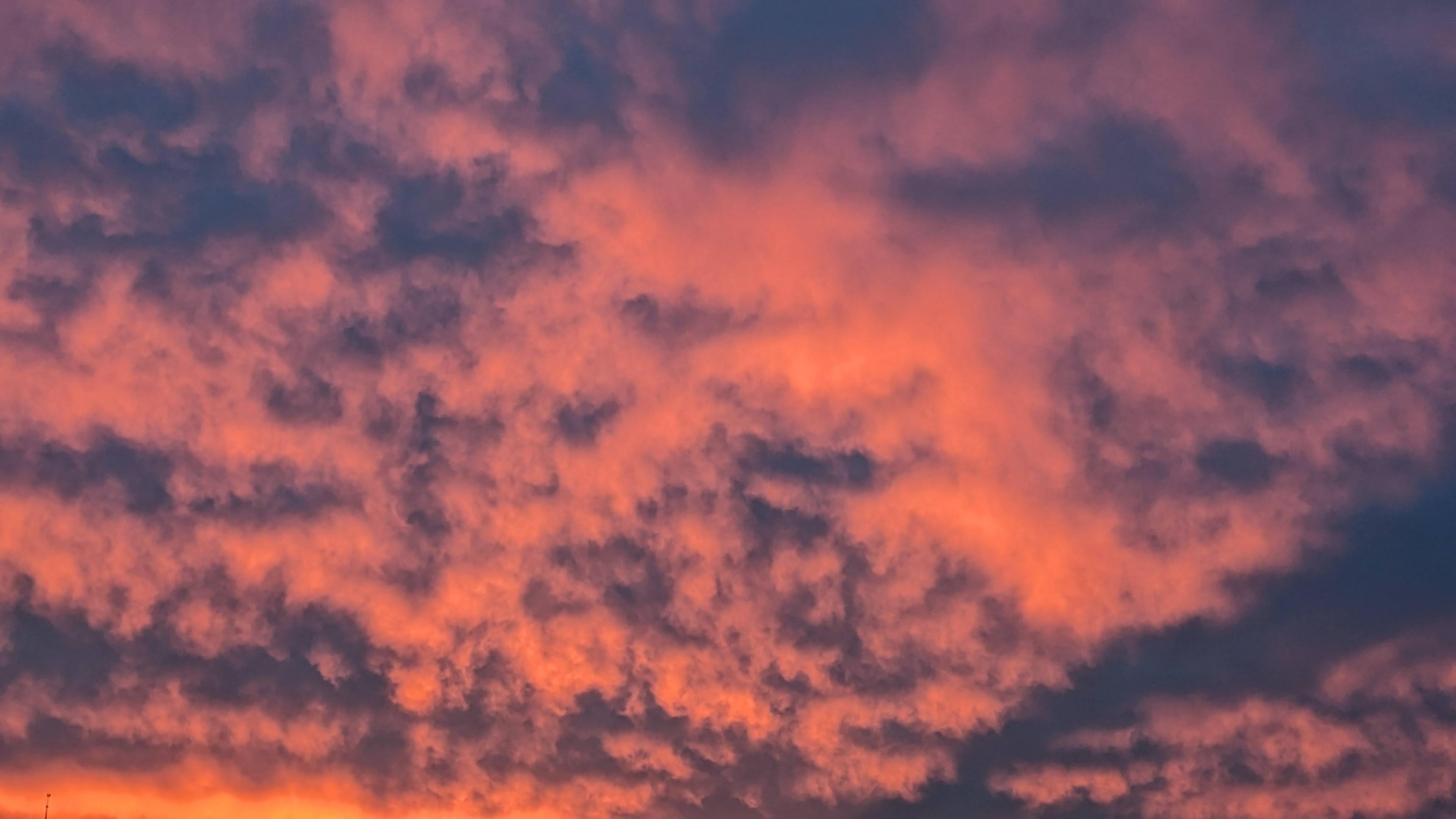 Bildbeschreibung von KI:
Das Foto zeigt einen Himmel voller dichter Wolken, die in intensiven Farben leuchten. Der Himmel ist in warme Orangetöne und kräftiges Rosa getaucht, die von den Strahlen der untergehenden Sonne stammen. Zwischen den hellen Wolkenfeldern schimmern dunklere Bereiche in Blau und Violett hindurch, die dem Bild Tiefe und Bewegung verleihen. Die Wolken wirken weich und unregelmäßig, fast wie Watte, und füllen das gesamte Bild, sodass kein Horizont zu sehen ist. Die kräftigen Farben vermitteln eine ruhige, aber gleichzeitig eindrucksvolle Stimmung, wie sie oft kurz vor Sonnenuntergang entsteht.
