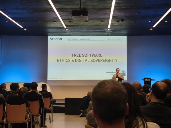 view of the stage at SFSCON 2025, with a speaker and slide.