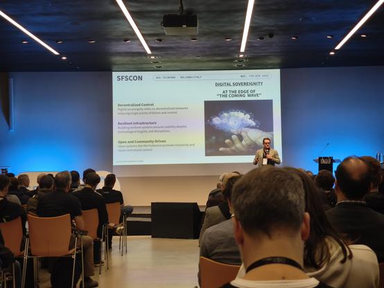 view of the stage at SFSCON 2025, with a speaker and slide.