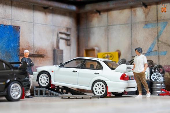 A Mitsubishi Lancer RS Evolution 6, Monte Carlo Edition, Scortia White by Hobby Japan in 1:64 scale with 1:64 figures on AREA 164.