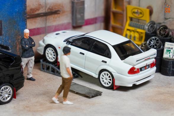 A Mitsubishi Lancer RS Evolution 6, Monte Carlo Edition, Scortia White by Hobby Japan in 1:64 scale with 1:64 figures on AREA 164.