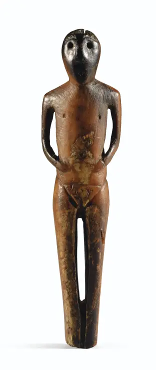 Anthropomorphic figurine with nipples on an otherwise flat chest and a prominent pubic triangle with pubic hair and a visible slit. It was made from the ivory of marine mammals and has developed a brown patina over time.