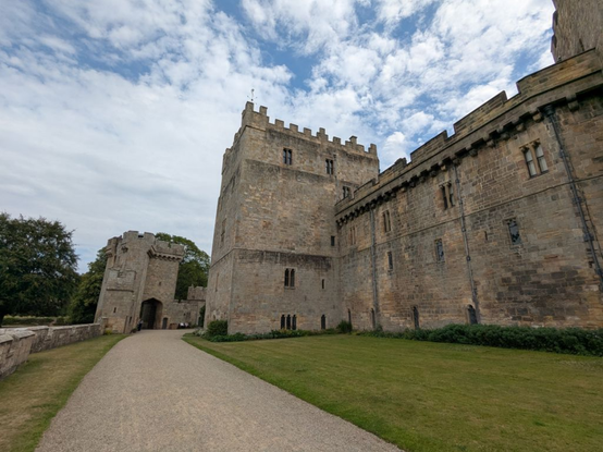 a photo of the side of the castle, big strong stone walls, it is very old looking 