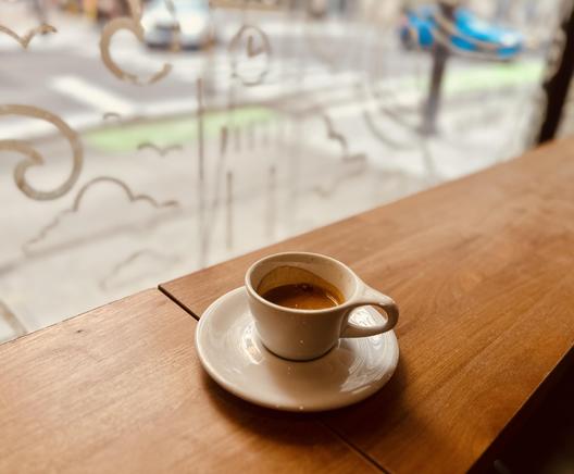 Ein großer Espresso in einer Tasse auf einem hölzernen Sideboard/Hochtisch. 