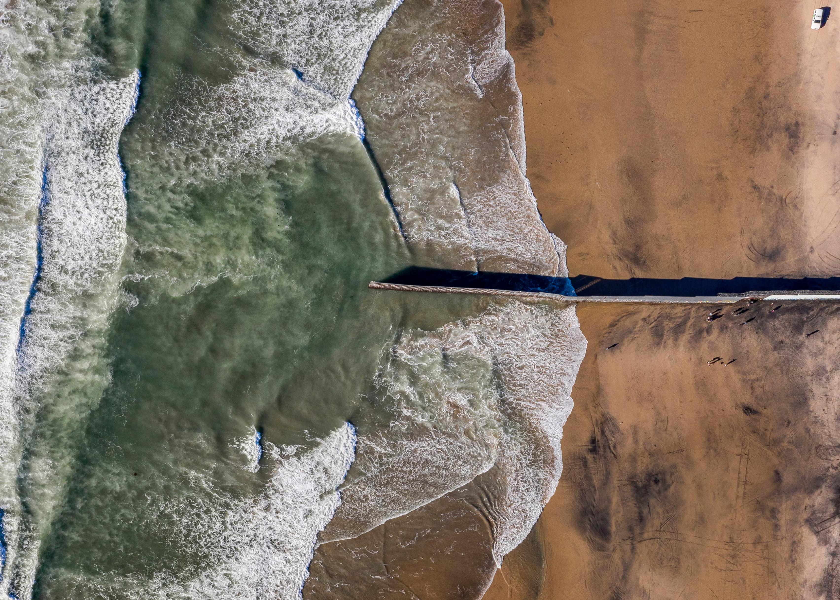 The border fence between Mexico and US suddenly ends at the Pacific Ocean.