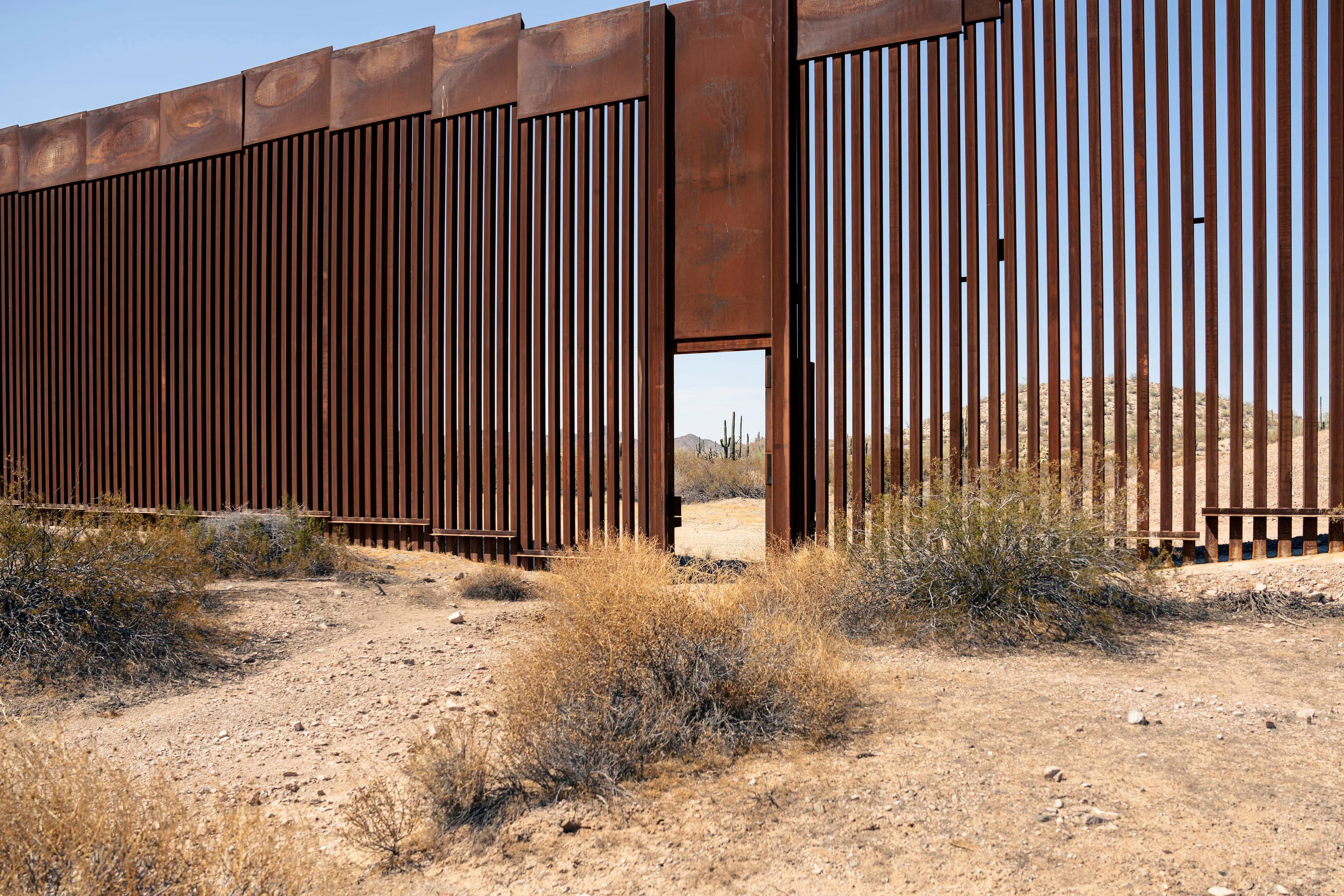 An open ‘door’ along the border fence between Sonora state in Mexico and Arizona in the US. The fence is made of interconnected steel slats.