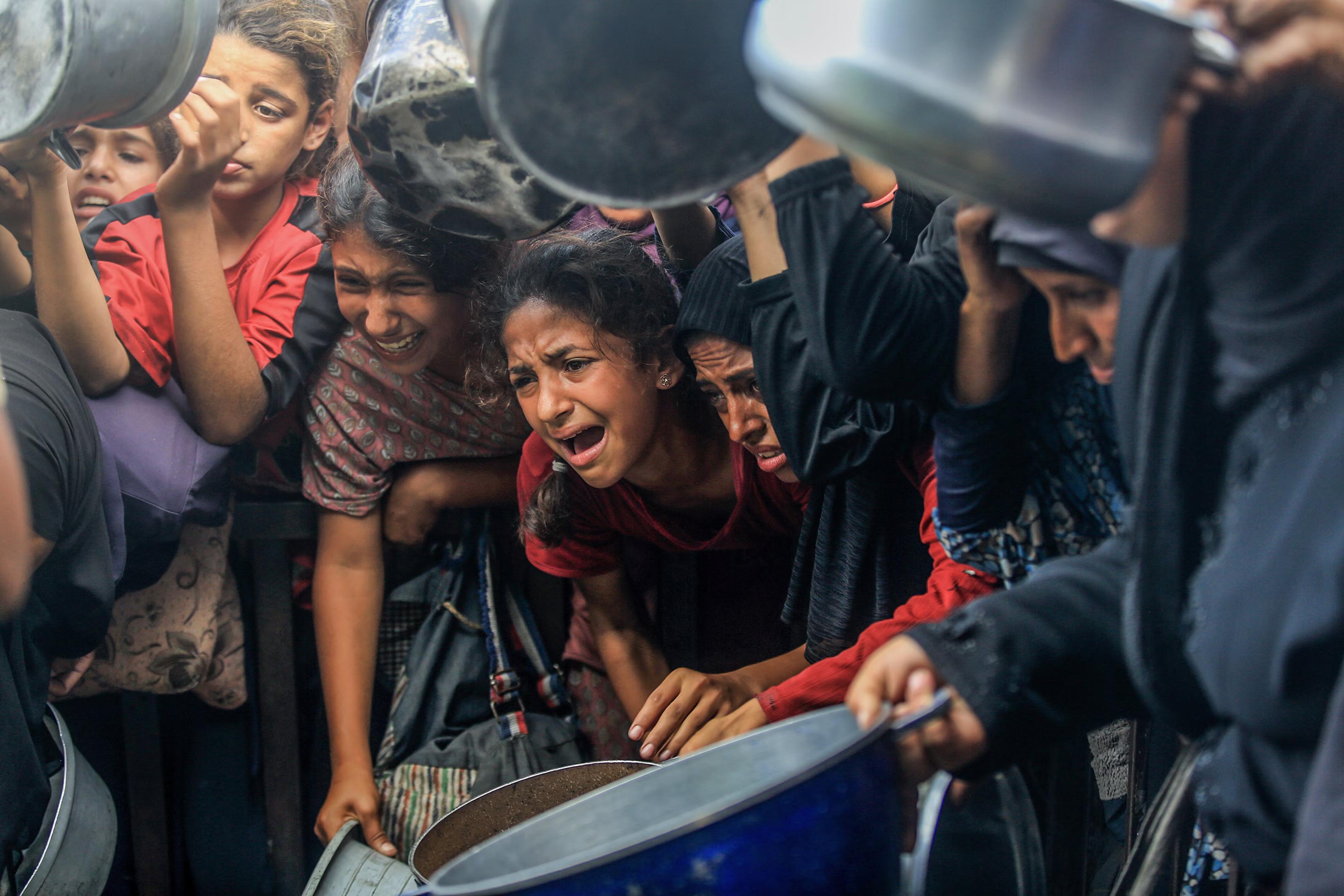Desperate Palestinians line up to receive food.
