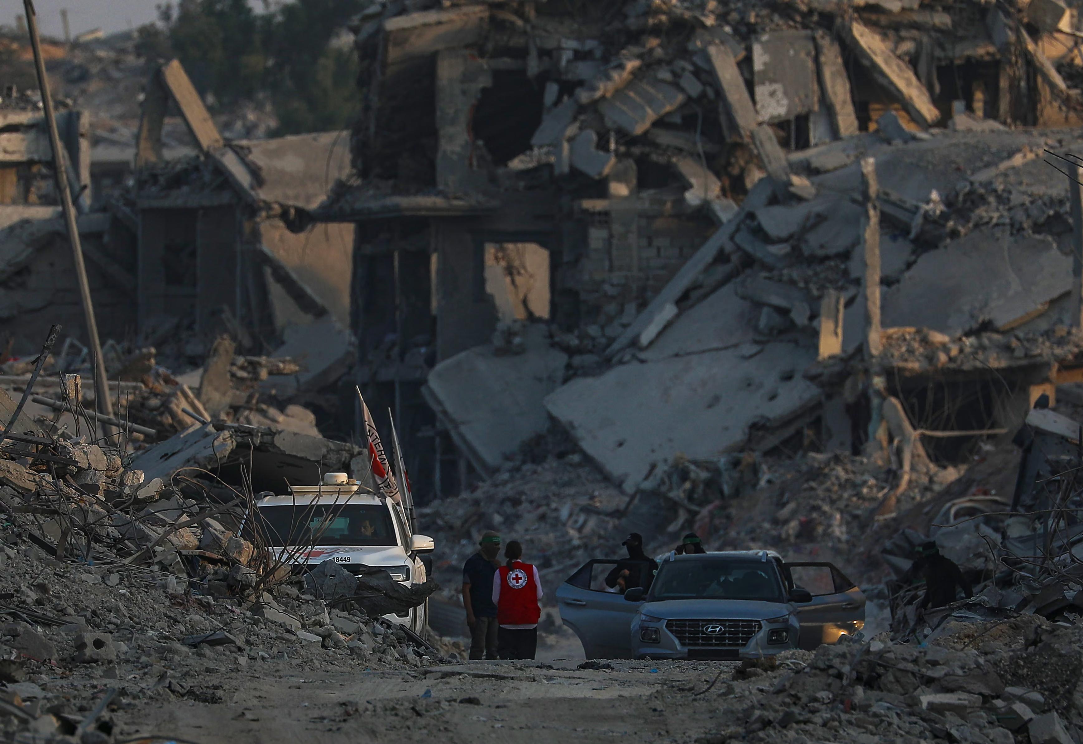 Red Cross workers assist as fighters of the al-Qassam brigades, the military wing of Hamas, search for the bodies of Israeli hostages in the Shuja’iya district.