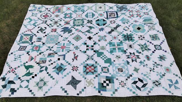  it is a quilt with many windows, turquoise and light red coral color, on a white background, it is large sized, lots of whimsical geometric shapes in diagonal rows 