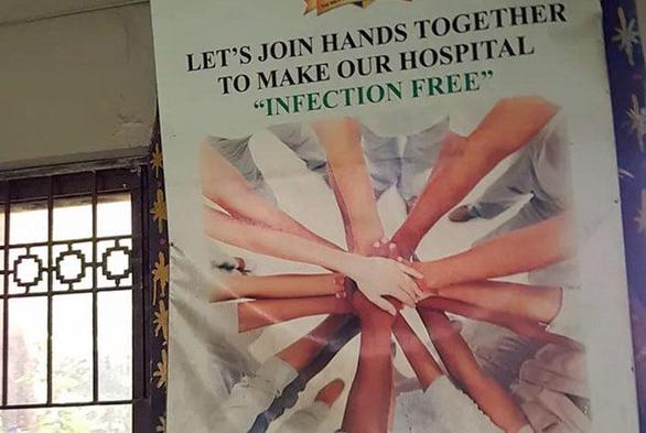 LET'S JOIN HANDS TOGETHER To "INFECTION FREE" MAKE OUR HOSPITAL "INFECTION FREE" [pic of like 10 people putting their hands all in]