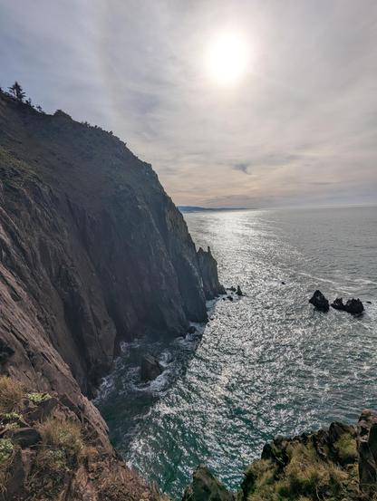 Pacific Ocean from Elk Flats trail in Oswald West State Park. Rock cliffs, sunshine, high thin clouds.