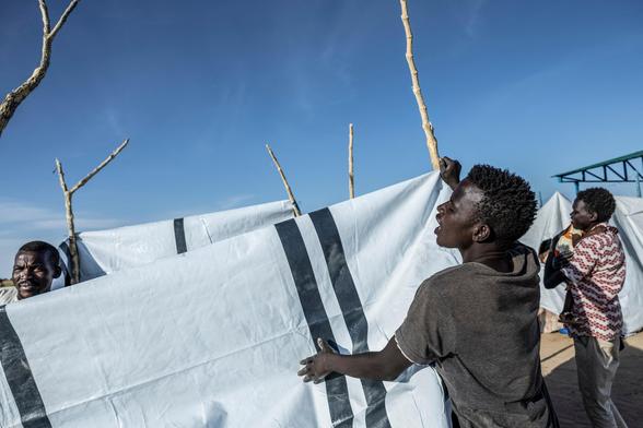 Sudanese refugees construct a shelter at the Tine transit camp.