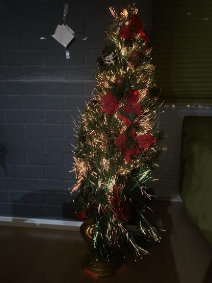 クリスマスツリー。電飾で細く光るタイプ。部屋の電気を消して光らせてみたところ。