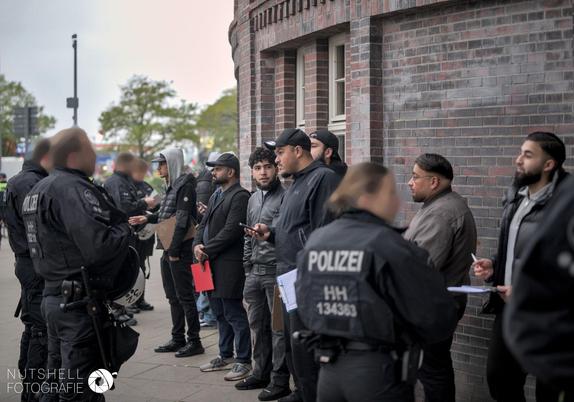 Unterschriftensammler und Flyerverteiler werden von der Polizei überprüft.