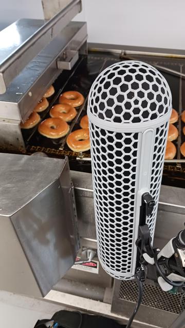 Mic recording near conveyor belt of doughnuts and hot oil