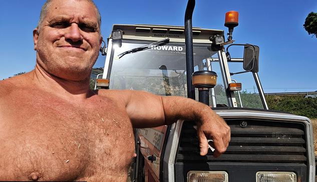 Hombre grande de campo junto a tractor