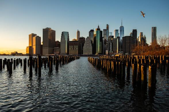 View across a filed of disused piers to New York City's financial district, by Adi Talwar for City Limits.