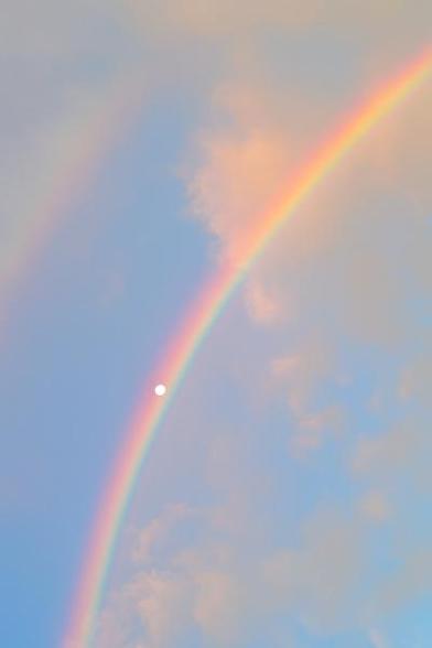  The moon perfectly framed by a rainbow. 