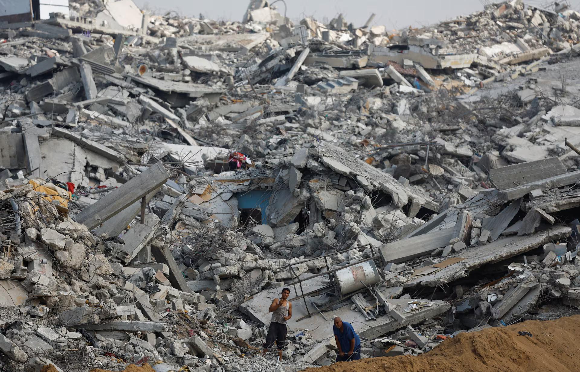 Palestinians work amid the rubble of destroyed buildings, during a ceasefire between Israel and Hamas, in Jabalia, northern Gaza Strip.