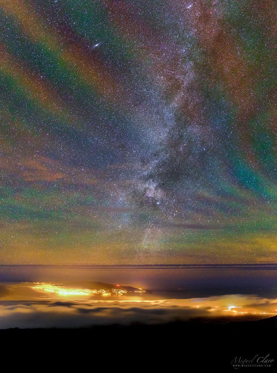 The long-duration exposure nearly along the vertical walls of airglow likely made the undulating structure particularly visible. OK, but where do the colors originate? The deep red glow likely originates from OH molecules about 87 kilometers high, excited by ultraviolet light from the Sun. The orange and green airglow is likely caused by sodium and oxygen atoms slightly higher up. The featured image was captured during a climb up Mount Pico in the Azores of Portugal. Ground lights originate from the island of Faial in the Atlantic Ocean. A spectacular sky is visible through this banded airglow, with the central band of our Milky Way Galaxy running up the image center, and M31, the Andromeda Galaxy, visible near the top left.
Image Credit & Copyright: Miguel Claro (TWAN); Rollover Annotation: Judy Schmidt