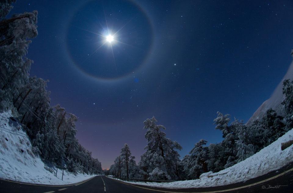 The brightest object, near the top of the featured image, is the Moon. Light from the Moon refracts through tumbling hexagonal ice crystals into a somewhat rare 22-degree halo seen surrounding the Moon. Elongating the 22-degree arc horizontally is a more rare circumscribed halo caused by column ice crystals. Even more rare, some moonlight refracts through more distant tumbling ice crystals to form a (third) rainbow-like arc 46 degrees from the Moon and appearing here just above a picturesque winter landscape. Furthermore, part of a whole 46-degree circular halo is also visible, so that an extremely rare -- especially for the Moon -- quadruple halo was captured. Far in the background is a famous winter skyscape that includes Sirius, the belt of Orion, and Betelgeuse -- visible between the inner and outer arcs. Halos and arcs typically last for minutes to hours, so if you do see one there should be time to invite family, friends or neighbors to share your unusual lensed vista of the sky.