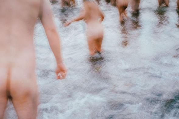 Blurred image of people participating in a skinny dip event in the water.