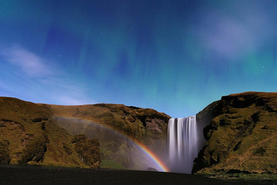This chromatic bow is not a rainbow, since the water drops did not originate in rainfall nor are they reflecting light from the Sun. Rather, the drops have drifted off from the waterfall and are now illuminated by the nearly full Moon. High above are the faint green streaks of aurora. The scene, captured one night last month, also shows a beautiful starscape far in the background, including the Big Dipper, part of the constellation of the Great Bear (Ursa Major).