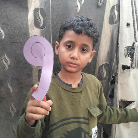 Saji is looking sad and he is holding a purple paper in the shape of number 9 because today is his birthday!