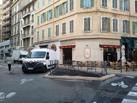 Îlot goudronné séparant les flux sur les chaussées à la sortie de la rue du Rouet et équipé de barrières croix Saint-André empêchant aux voitures et camions de se garer dessus.