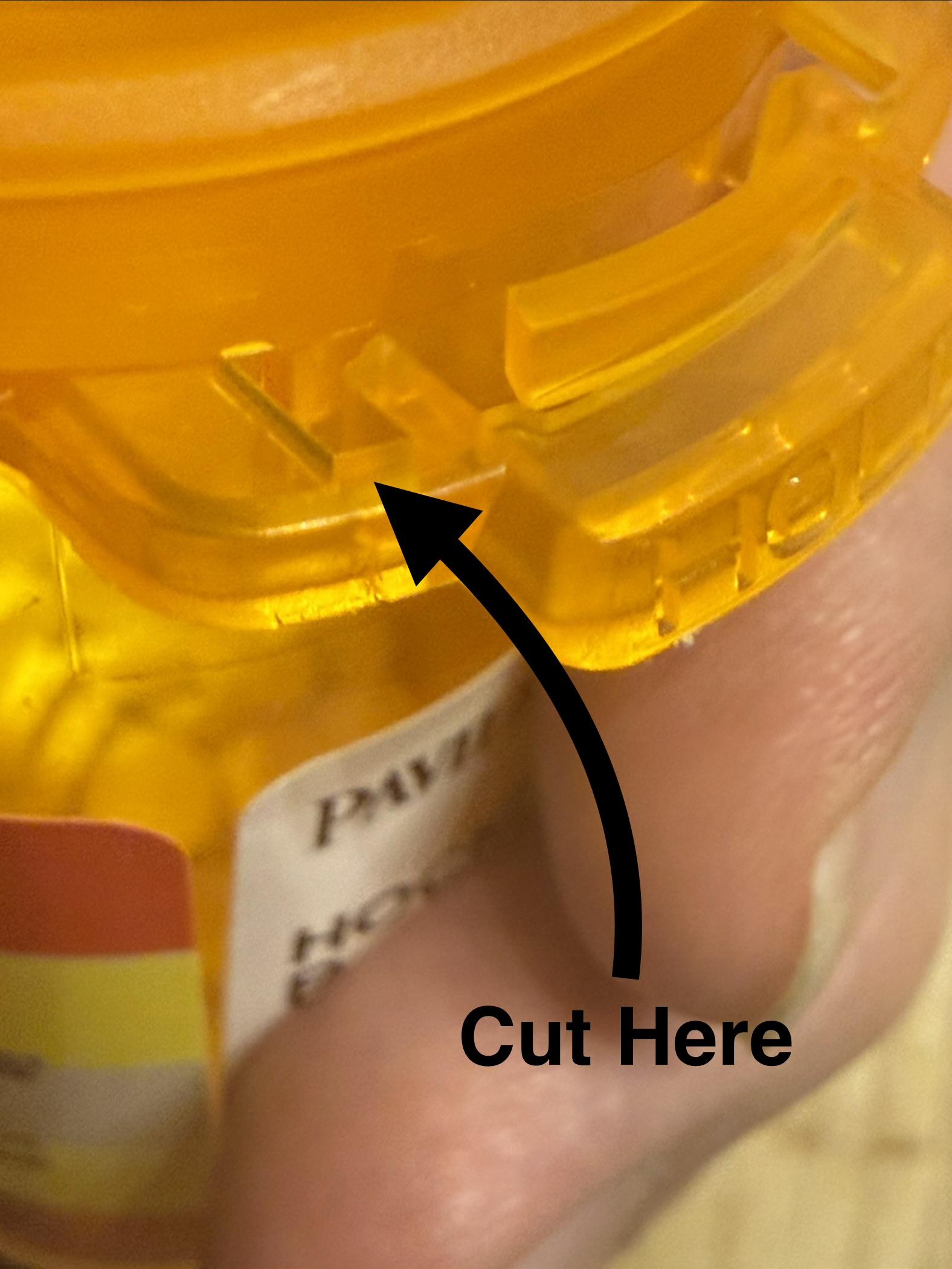 Images shows an arrow where to cut:

Cut at the side tab just after the point where it goes from being thick to thin. It’s the part that supports the spring that locks the cap.
