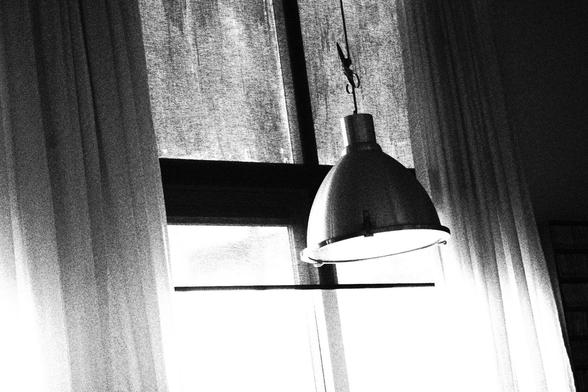 A hanging lamp tied around a pair of scissors