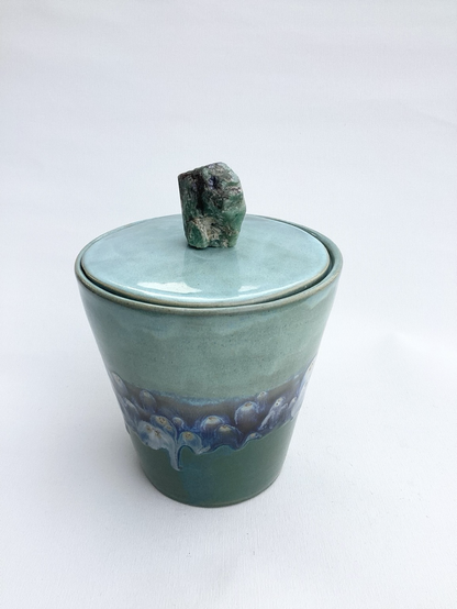 Dose, die sich geradlinig nach oben weitet. Unten eine türkisblaue Glasur, oben blau und im Übergangsbereich eine dunkelblaugraue mit weißen Einschlüssen. Stein ist ungeschliffen, grünlich wie roher Smaragd.