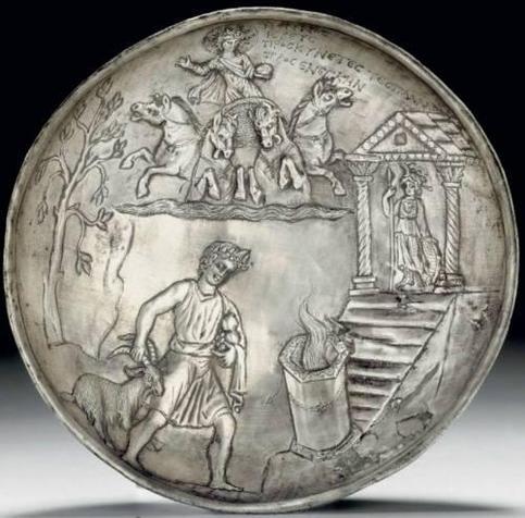 Silver bowl with a sacrifice scene in relief: a youthful priest wearing a flowing sleeveless tunic and a mantle rolled around his waist and draped over his left arm, a laurel wreath in his full curly locks, cradling pomegranates and other fruit in the crook of his left arm, gripping a goat by its horn, leading it toward a flaming hexagonal altar, embellished with scrolling dots on the upper surface and base, a wreath around its center, the altar situated at the base of the steps of a Temple to …